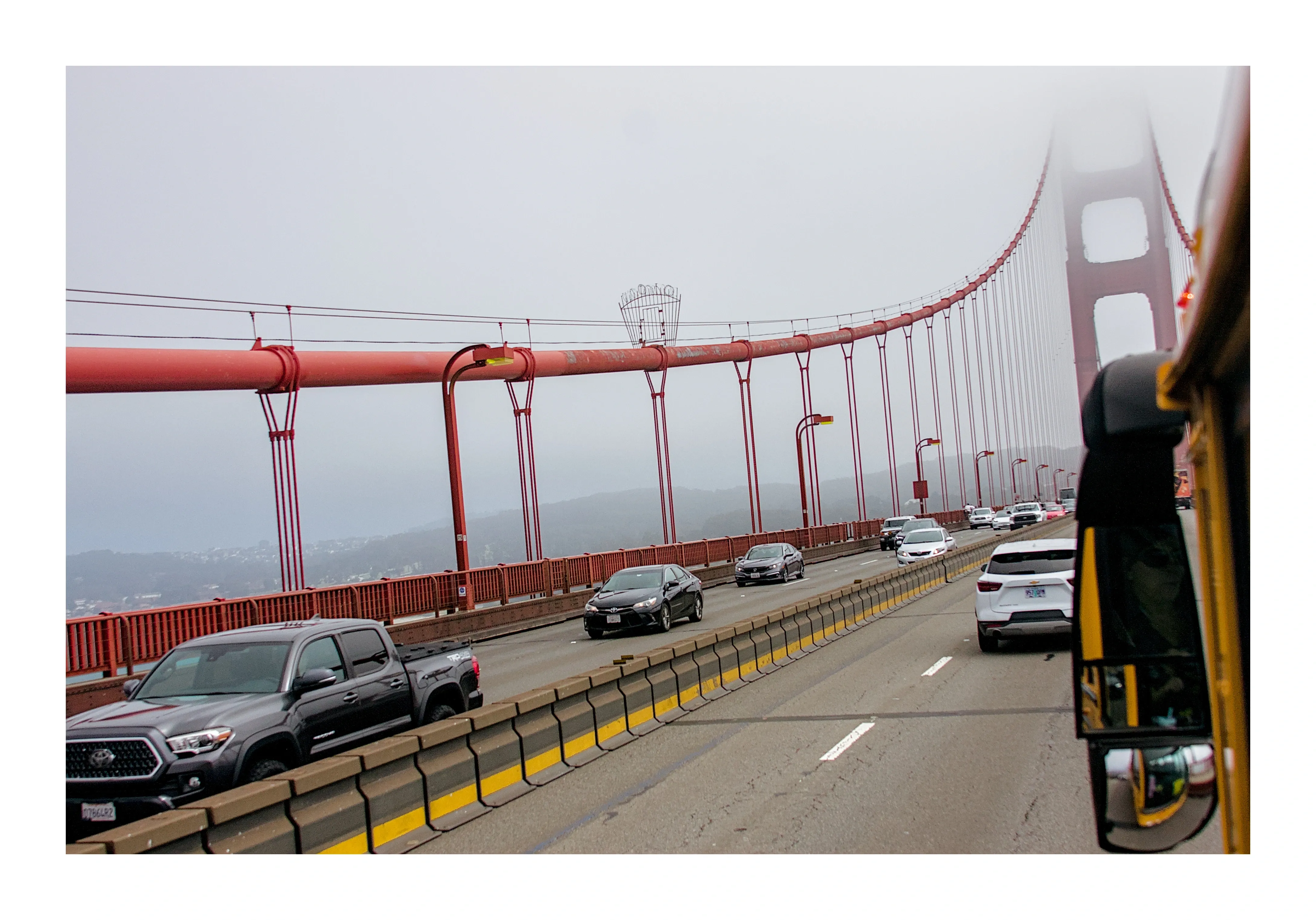 The Golden Gate Bridge disappearing into fog, seen from a bus